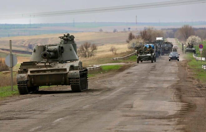 Russian military vehicles move on a highway in an area controlled by Russian-backed separatist forces near Mariupol, Ukraine, Monday, April 18, 2022.