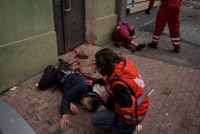 Emergency workers help injured civilians during a Russian bombardment in Kharkiv, Ukraine, Sunday, April 17, 2022.