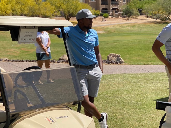 Ryan Alford leans on a golf cart after hitting his opening tee shot.  Alford won last year's Advocates Professional Golf Association event at TPC Scottsdale.