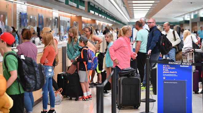 Travelers check their bags at the Southwest Arilines ticket counter Tuesday at Sarasota-Bradenton International Airport. Facemasks, once required on public transportation due to the COVID-19 pandemic, are now optional after a federal judge lifted the nationwide travel mask mandate on Monday. 