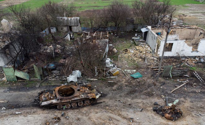 The wreckage of a tank is seen next to destroyed residential houses in the village of Zalissya, northeast of Kyiv on April 19, 2022.