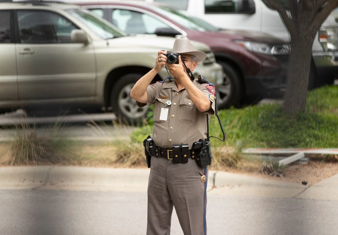 A state trooper photographs a rally to legalize marijuana at the Governor’s Mansion on Wednesday, April 20.