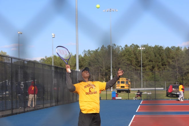 CJ Claiborne watches the ball before a serve in the individual matches.