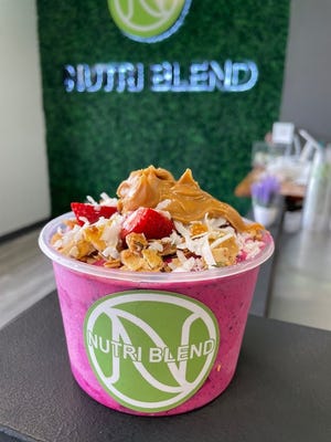 The Pitaya Bowl at Nutri Blend topped with granola, strawberries, shredded coconut, peanut butter and raw honey.