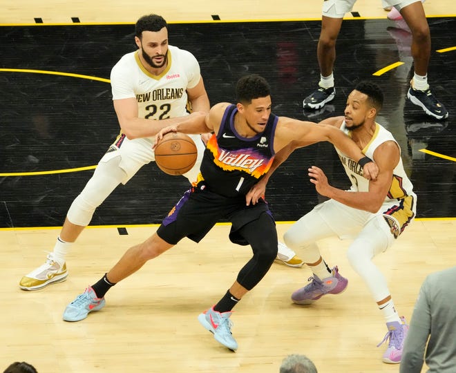 Apr 19, 2022; Phoenix, Arizona, U.S.;  Phoenix Suns guard Devin Booker (1) is double-teamed by New Orleans Pelicans forward Larry Nance Jr. (22) and guard CJ McCollum (3) during Game 2 of the Western Conference playoffs.