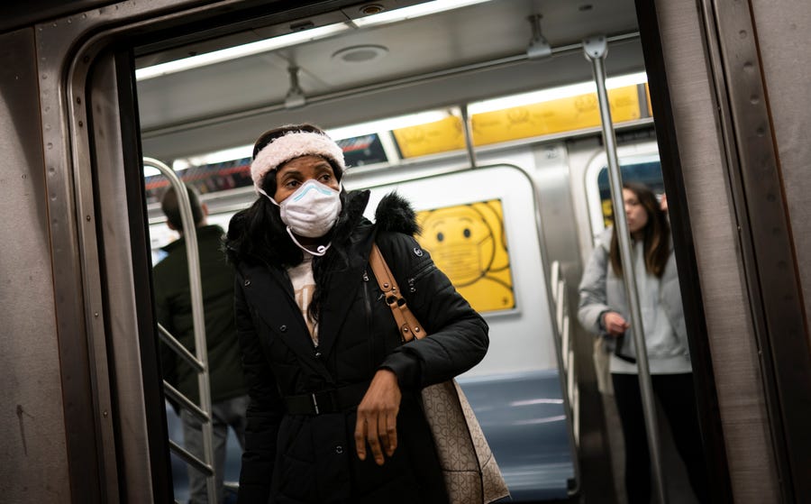 Mass transit riders wear masks as they commute in the financial district of lower Manhattan, Tuesday, April 19, 2022, in New York. U.S. District Judge Kathryn Kimball Mizelle in Tampa, Fla., on April 18, 2022, voided the national travel mask mandate as exceeding the authority of U.S. health officials. The mask mandate that covers travel on airplanes and other public transportation was recently extended by President Joe Biden's administration until May 3. (AP Photo/John Minchillo) ORG XMIT:   NYJM105