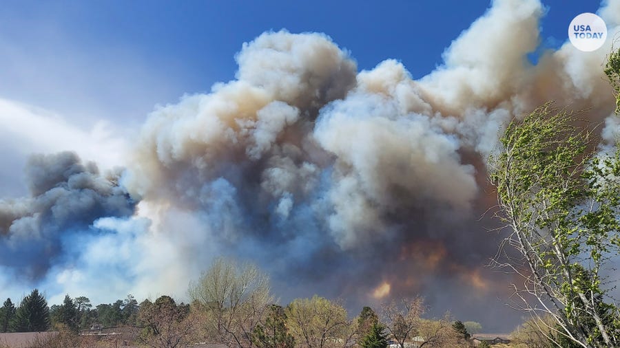 Smoke from a wind-whipped wildfire rises above neighborhoods on the outskirts of Flagstaff, Arizona.