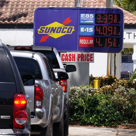 Cars line up at a Sunoco gas station offering high