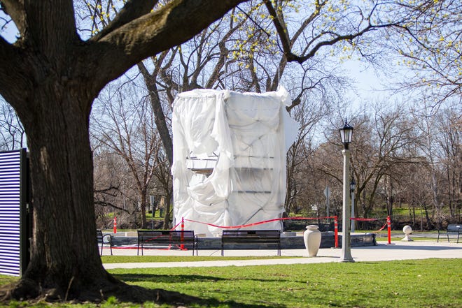 Studebaker Electric Fountain is covered in plastic and scaffolding during sandblasting maintenance to clean the historic structure on Thursday, April 21, 2022, in South Bend. 