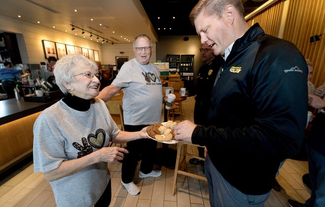 Michele Lee of Springfield offers cookies to Springfield Police Department Deputy Chief Joshua Stuenkel as Bob Locke of Springfield gives Lee a pat on the back at the Starbucks on Dirksen Parkway, where police officers met with residents over coffee Thursday. [Thomas J. Turney/The State Journal-Register]