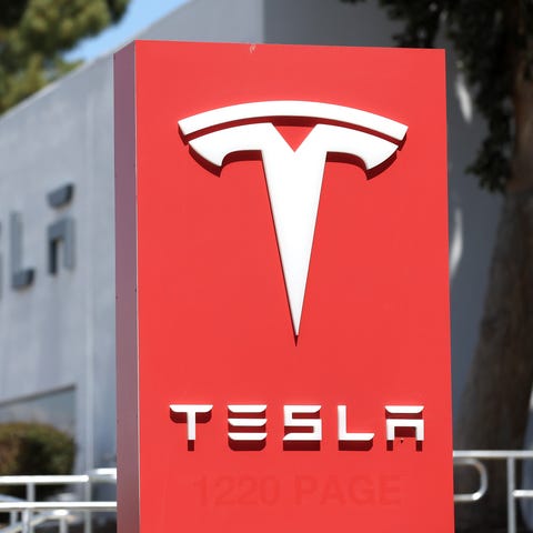 A sign is posted in front of a Tesla service cente