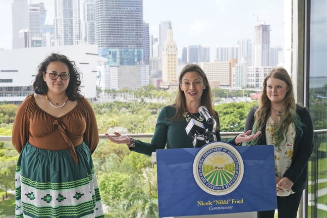 Florida Commissioner of Agriculture and Consumer Services Nikki Fried, center, speaks during a news conference along with youth climate leaders, Valholly Frank, left, and Delaney Reynolds, right, Thursday at the Phillip & Patricia Frost Museum of Science in Miami.