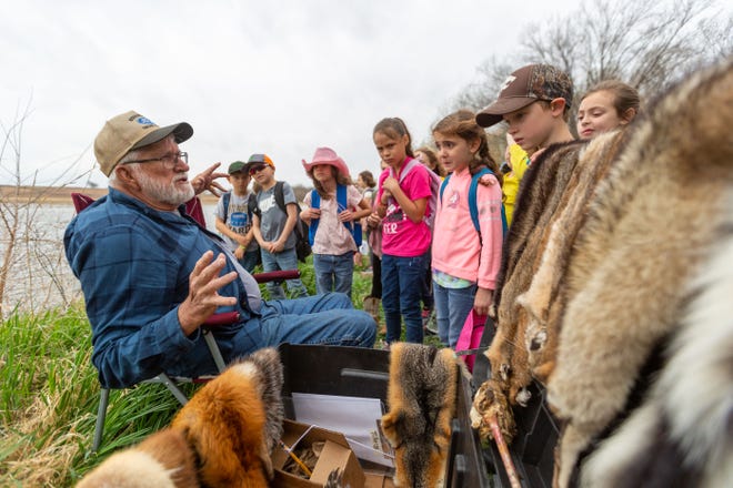 Merlyn Mahoney, a retired printer, teaches a group of Valley Falls Elementary second graders about the various animals that live in marshes like the ones at the Perry Wildlife Area on the students' Earth Day field trip Friday.