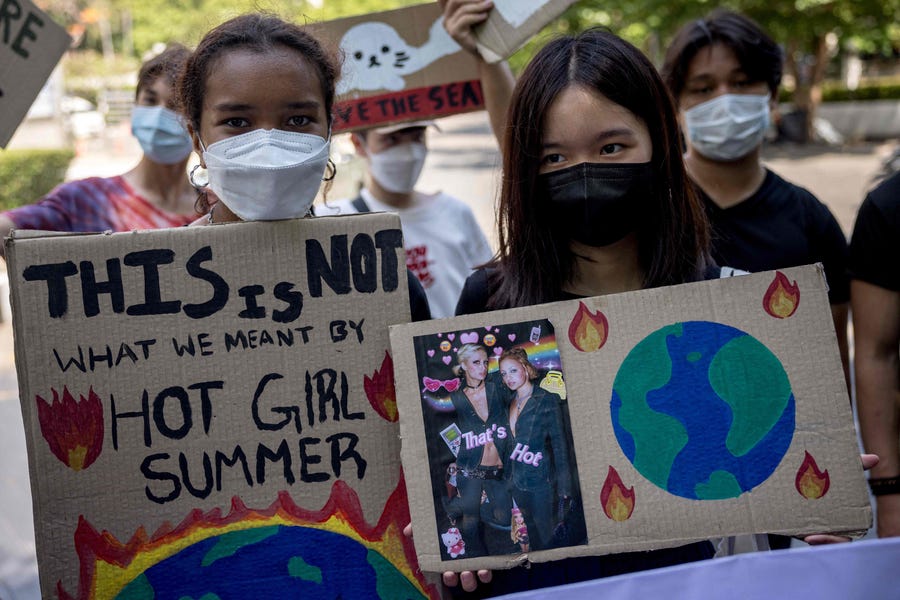Young protesters carry placards as they take part in a Climate Strike march towards Thailand's Ministry of Natural Resource and Development to mark Earth Day in Bangkok on April 22, 2022.