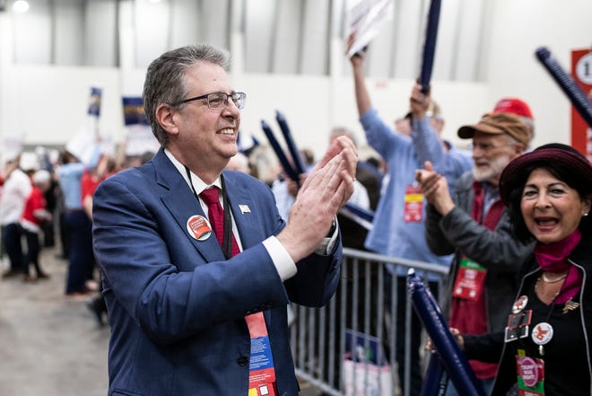 Attorney General candidate Matt DePerno applauds as he walks by supporters during the MIGOP State Convention at the DeVos Place in Grand Rapids on April 23, 2022.