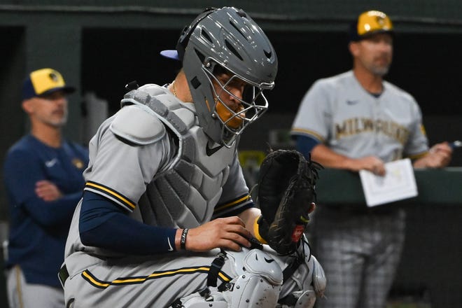 Brewers catcher Victor Caratini uses the PitchCom system on his right shin guard to communicate with starting pitcher Corbin Burnes during 
a game earlier this season.