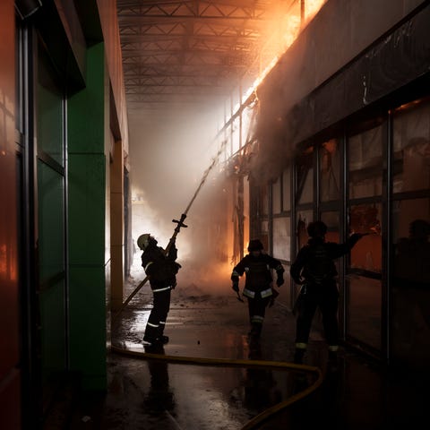 Firefighters work to extinguish a fire at a shop f