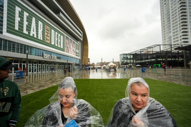 Diana Peil and her daughter, Kayla Badger, 28, clutch their rain ponchos before watching the first-round Eastern Conference playoff series between the Milwaukee Bucks and Chicago Bulls on Sunday, April 24, 2022, in the Deer District in Milwaukee. Sunday was Badger’s birthday. “My day was really good before it started raining,” she said.