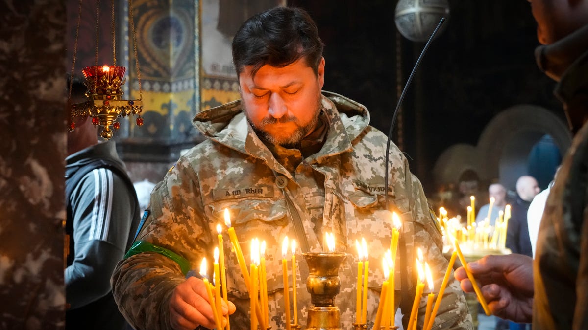 A Ukrainian soldier lights candles at the Volodymysky Cathedral during Easter celebration in Kyiv, Ukraine.