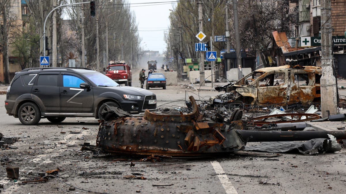 A part of a destroyed tank and a burned vehicle sit in an area controlled by Russian-backed separatist forces in Mariupol, Ukraine, Saturday, April 23, 2022. 