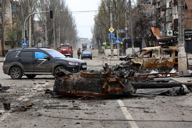 A part of a destroyed tank and a burned vehicle sit in an area controlled by Russian-backed separatist forces in Mariupol, Ukraine, Saturday, April 23, 2022. 