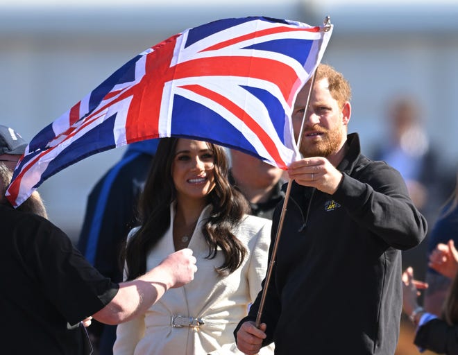 Prince Harry and Meghan, the Duke and Duchess of Sussex, wave a Union Jack at the competitions on day two of the Invictus Games at Zuiderpark on April 17, 2022 in The Hague, Netherlands.