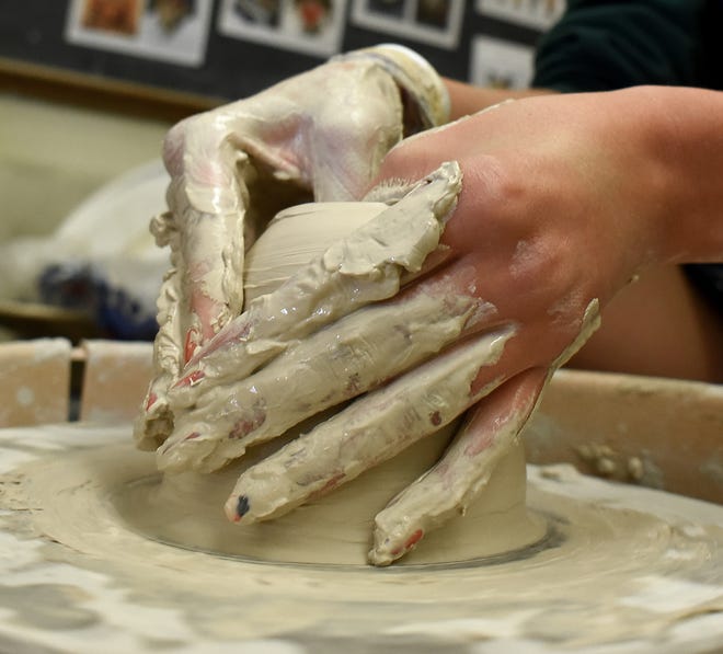 The hands of St. Mary Catholic Central student MacKenzie Kidd works on a clay bowl in class.