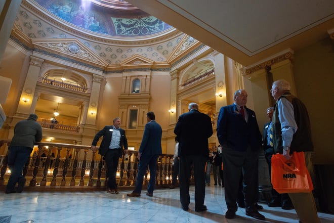 Lobbyists congregate outside the House Chambers before the start of Monday's veto session at the Statehouse.
