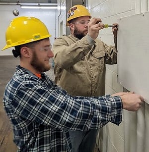 Cody Brenlish and Cole Wright open an electrical box on an industrial jobsite. They are members of the International Brotherhood of Electrical Workers Local 1105 who work in Coshocton County. The electrical field is on the rise due to increased home and industrial site construction.
