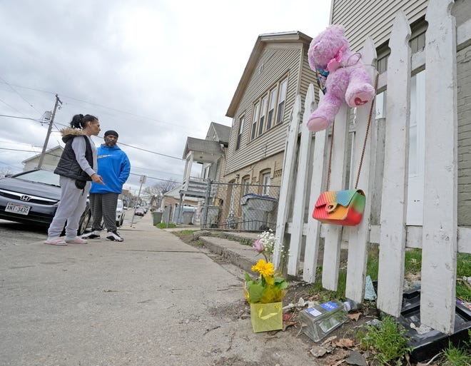 People stand at the scene where a 13-year-old  was killed during a shooting Sunday on Milwaukee's south side in the 1900 block of South Fifth Street, near Rogers Street in Milwaukee on Monday, April 25, 2022, that also injured two other young people.