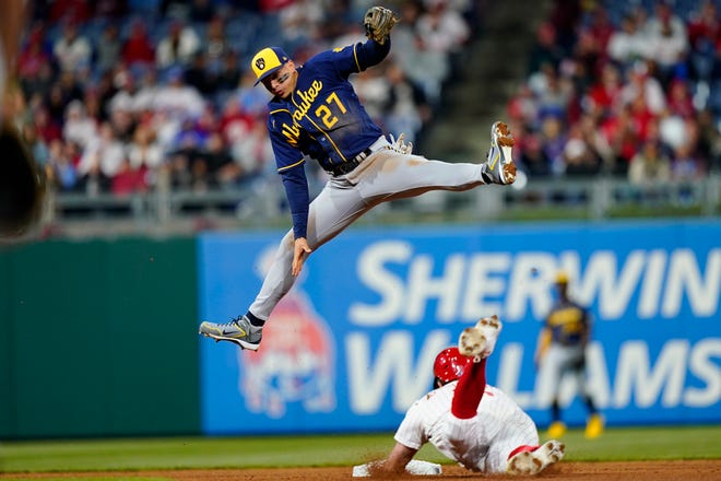 Brewers shortstop Willy Adames leaps for the throw as Kyle Schwarber of the Phillies slides into second base for a double during the fifth inning Sunday.