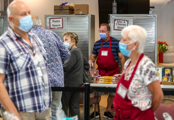 Volunteer Jeff Bergen helps a client at the Cathedral City Senior Center food bank in Cathedral City, Calif., Monday, April 25, 2022. 