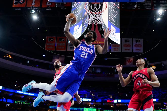The Sixers' Joel Embiid, 21, goes up for a shot between the Raptors' Khem Birch, left, and Scott Barnes in Game 5 on Monday night.