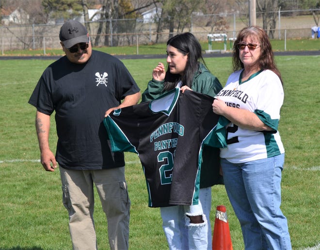 The Pennfield lacrosse program retired the number of AJ Moya, who passed away in 2021, as he jersey was presented to his parents Renee, right, and Art Moya, left, and his sister Marisa Moya at the All-City Lacrosse Tournament on Saturday at Pennfield High School.