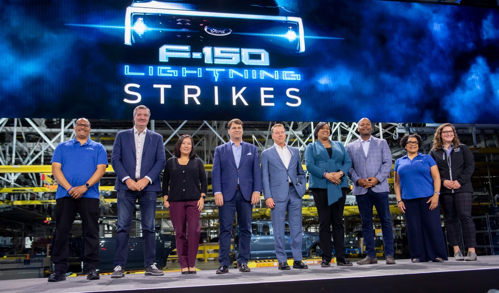 Ford executives, management, and a UAW labor representative pose for a photo during the launch celebration for the Ford F-150 Lightning at the Rouge Electric Vehicle Center, in Dearborn, April 26, 2022.