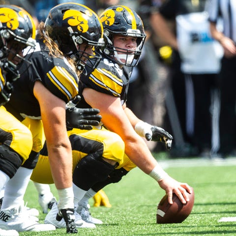 Iowa center Tyler Linderbaum (65) gets ready to sn