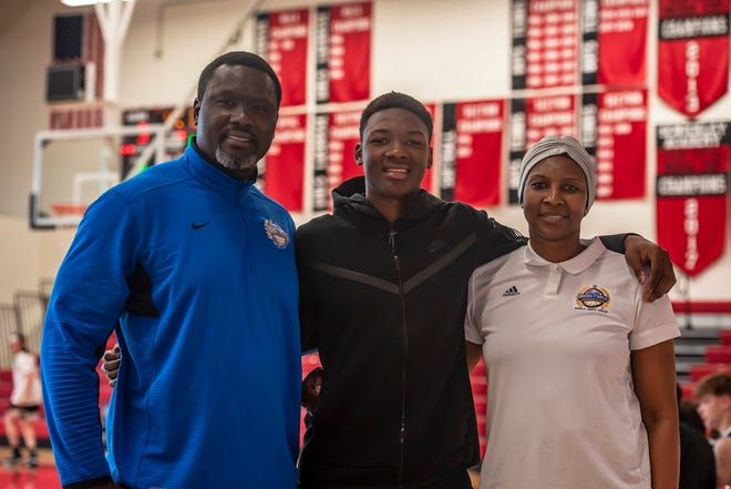 Adou Thiero stands with his father, Almamy Thiero, and his mother, Mariam Sy, in the gym at Sewickley Academy. Almamy is an assistant coach at Sewickley Academy.