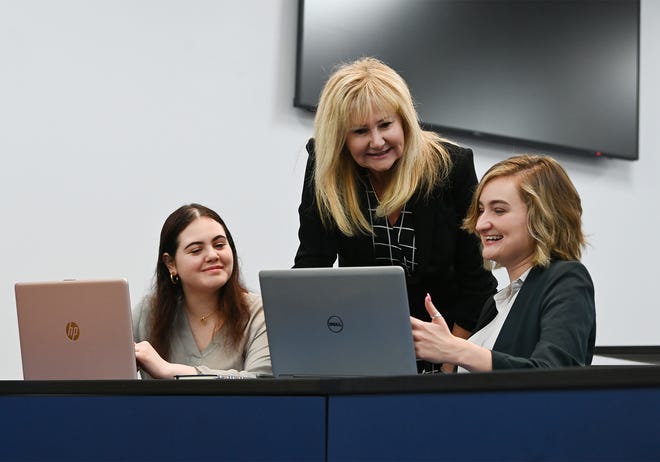 University of North Florida Women in Business program members Kate Los, left, and Mary Joy DiMarco, right meet with Professor Leslie Gordon, director of the empowerment program.