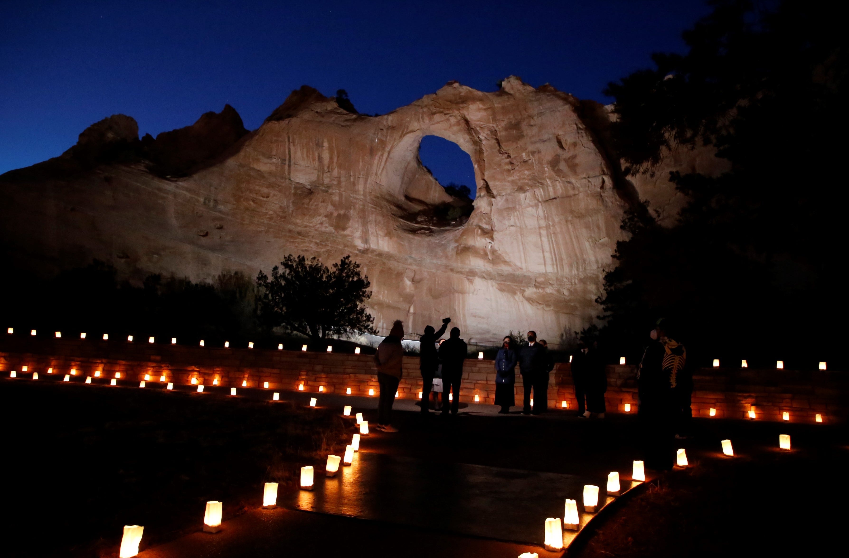 The Window Rock formation is illuminated on March 17 in Window Rock, Ariz. during an event to remember members of the Navajo Nation who died of COVID-19.