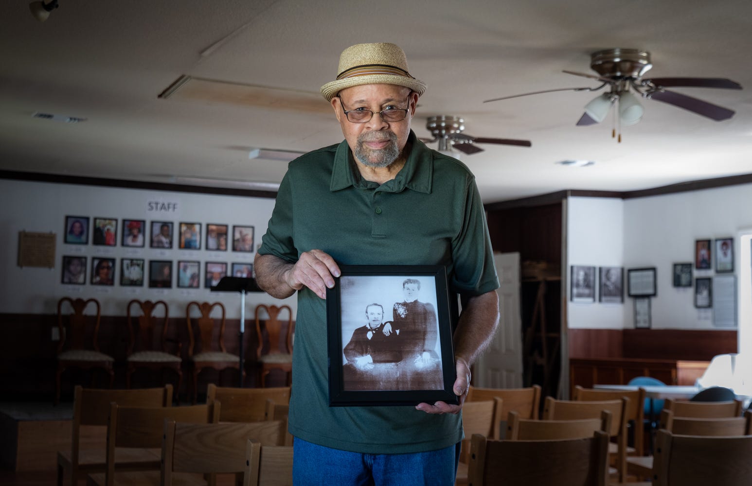 A man holds a photo of his great great grandparents