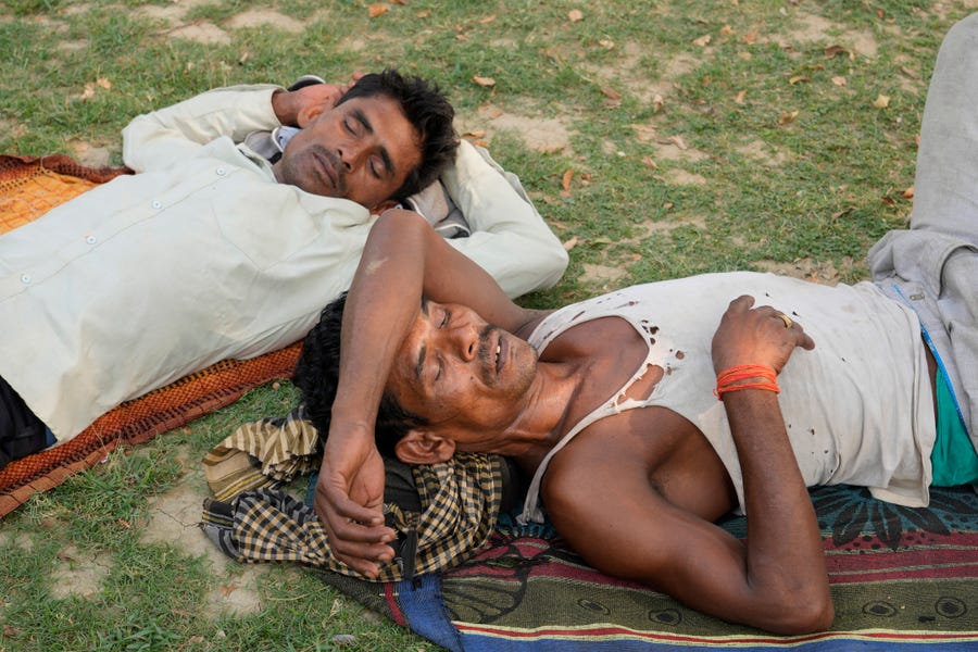 People sleep in the shade of a tree on a hot summer afternoon in Lucknow in the central Indian state of Uttar Pradesh on April 28. Severe heat wave conditions swept north and western parts of India.