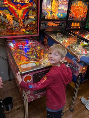 A child plays pinball at The Regent Arcade's new location on Locust Street in downtown Allegan.