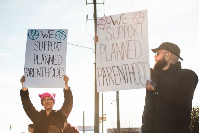 Supporters of Planned Parenthood display signs to counter an anti-abortion rally in Fayetteville in February 2017.