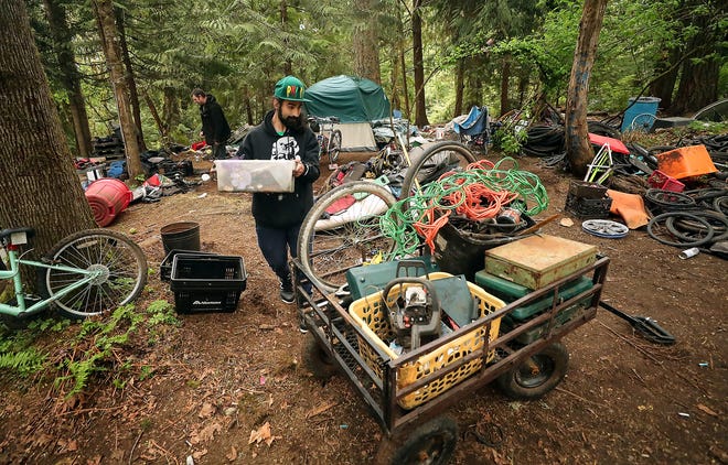 Anthony (no last name given) helps load belongings into a cart as his friends move out of their campsite in Veterans Memorial Park in Port Orchard on Friday. Anthony used to live in Veterans Memorial Park but found somewhere else to live recently and came back to help his friends that were being evicted from the park.