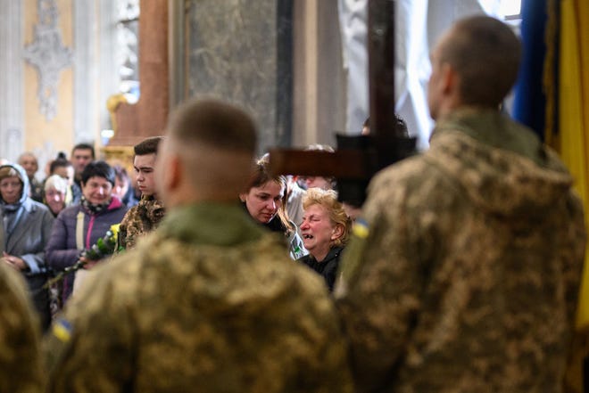 Anna Tazaeva (kanan tengah) berduka atas putranya selama upacara pemakaman prajurit yang gugur Lubomyr Tazaev, berusia 36 tahun, di Gereja Saint's Peter and Paul Garrison pada 29 April 2022 di Lviv, Ukraina.