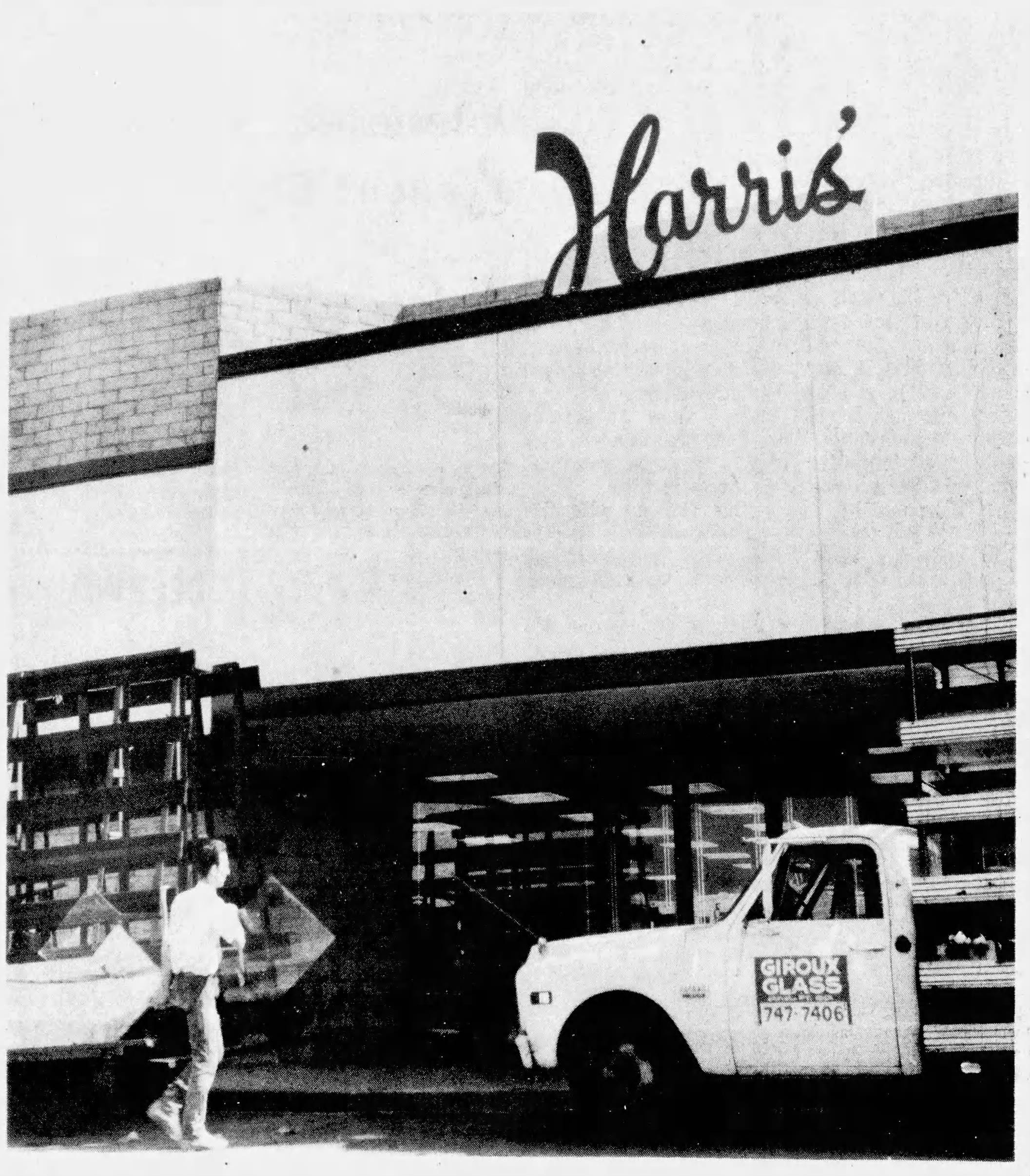 A workman carries a plate of glass into Harris' Department Store completing the final stages of construction for the Indio Fashion Mall in 1975.
