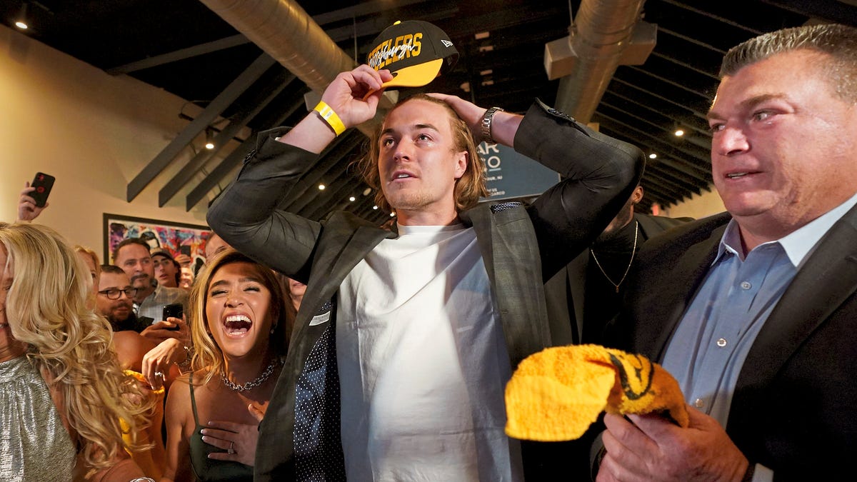 Former Pittsburgh quarterback Kenny Pickett reacts next to his fiancee, Amy Paternoster, and his father, Ken, on Thursday, April 28, 2022, in Loch Arbour, N.J., after learning that the Pittsburgh Steelers had chosen him in the NFL draft.