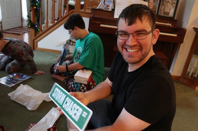 Gavin Short, 19, is pictured holding a storm chaser sign he was gifted with at Christmas in December 2021.