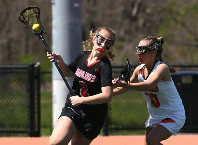 Marblehead's Ramona Gillett, left, fends off Wayland's Carly Travis during the second half of a non-league game at Wayland High School on April 30.