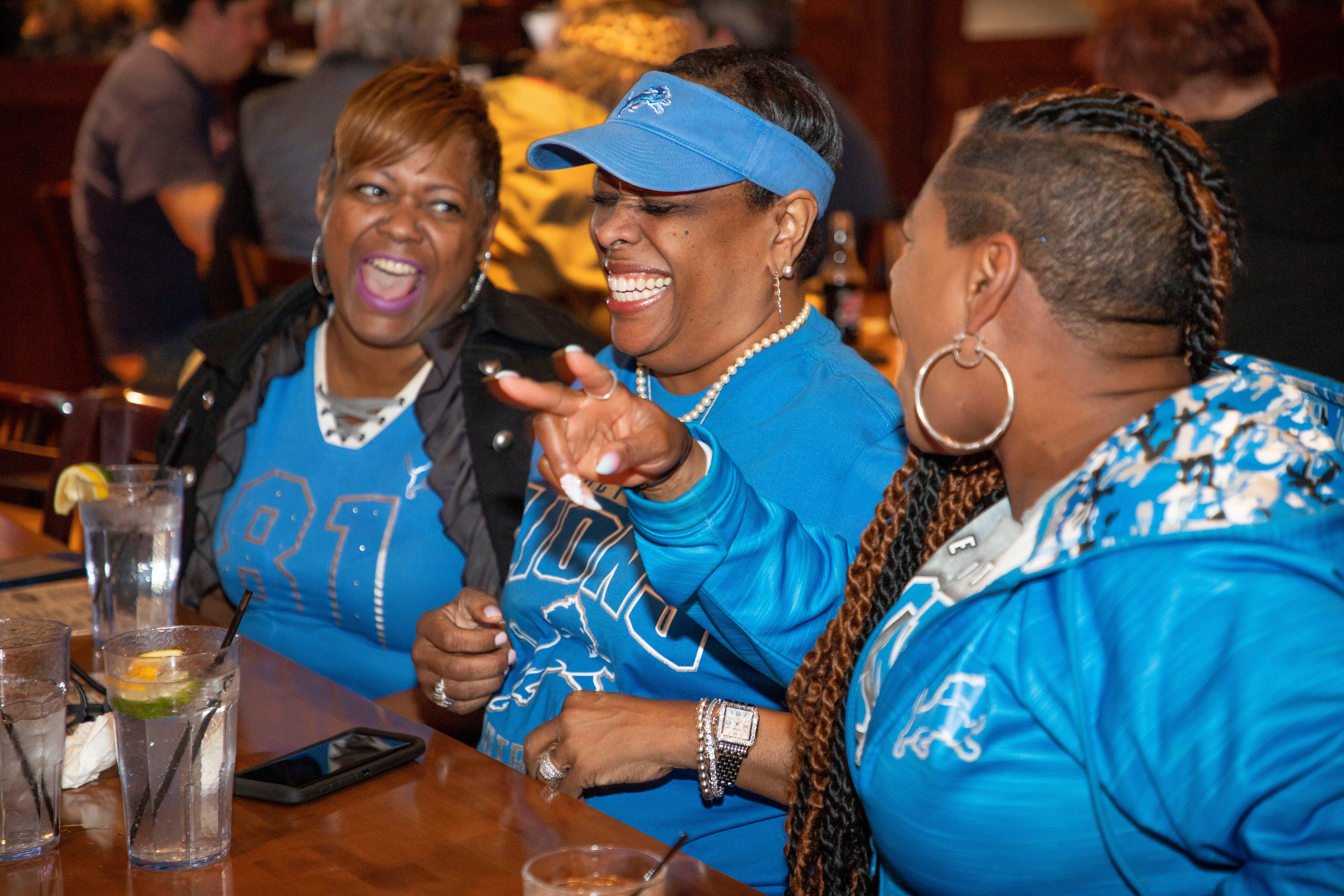 From left, Deshawn Johnson, Tracey Spencer and Jacquelyn Jarrett talk memories of seasons past at the beginning of day 2 of the NFL Draft on April 29, 2022, that brought 10 proud members of the Detroit Lions Tailgating Divas to Mr. Joe's Bar and Grill in Southfield. Before the Lions selected Kentucky defensive end Josh Paschal with the team's first pick of Day 2, the Divas celebrated their longtime friendships and even accepted a friendly challenge from another fan to sing the Lions fight song. 